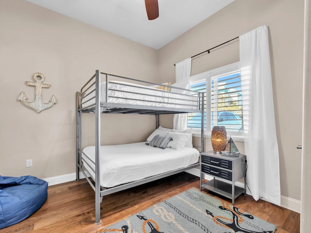 bedroom with a ceiling fan, baseboards, and wood finished floors