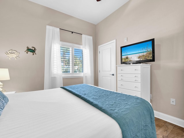 bedroom with baseboards, wood finished floors, and a ceiling fan