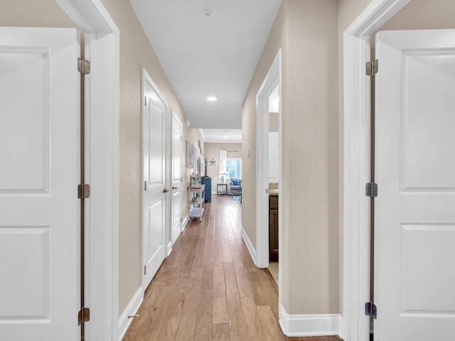 corridor with recessed lighting, baseboards, and light wood finished floors