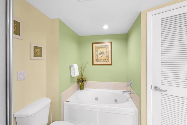full bath with toilet and a tub with jets