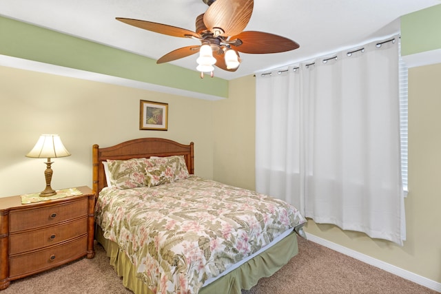 bedroom featuring baseboards, light colored carpet, and a ceiling fan