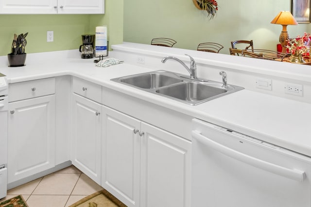 kitchen featuring a sink, dishwasher, white cabinets, and light tile patterned floors