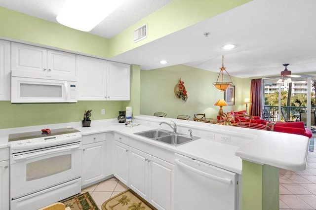 kitchen with white appliances, light tile patterned floors, a peninsula, a sink, and light countertops
