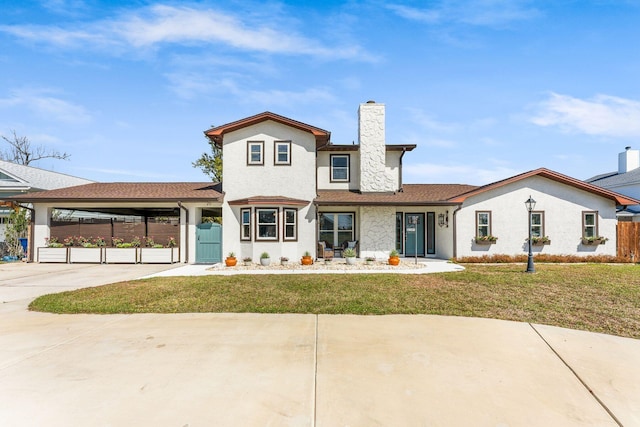 view of front of house with a carport, a chimney, a front lawn, and fence