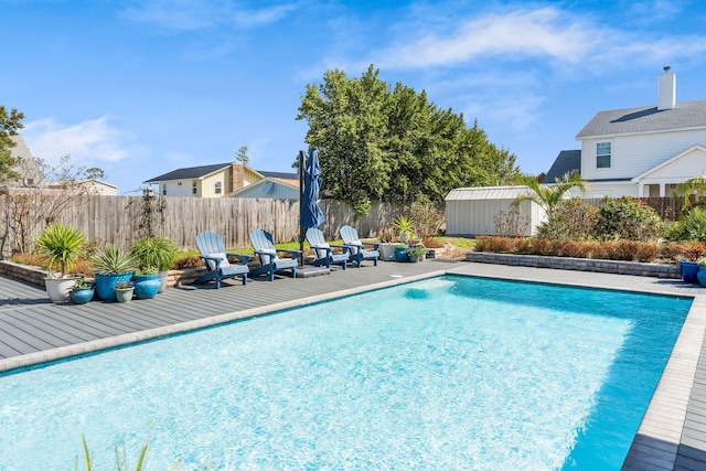 view of swimming pool with an outbuilding, a shed, a fenced in pool, and a fenced backyard