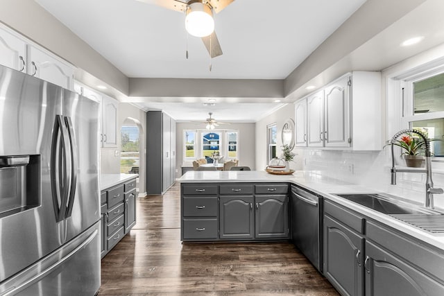 kitchen featuring gray cabinetry, a sink, stainless steel appliances, a peninsula, and white cabinets