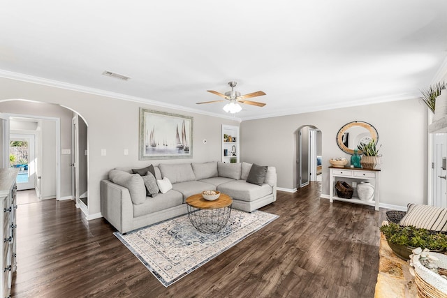 living area with visible vents, arched walkways, dark wood-type flooring, and ornamental molding