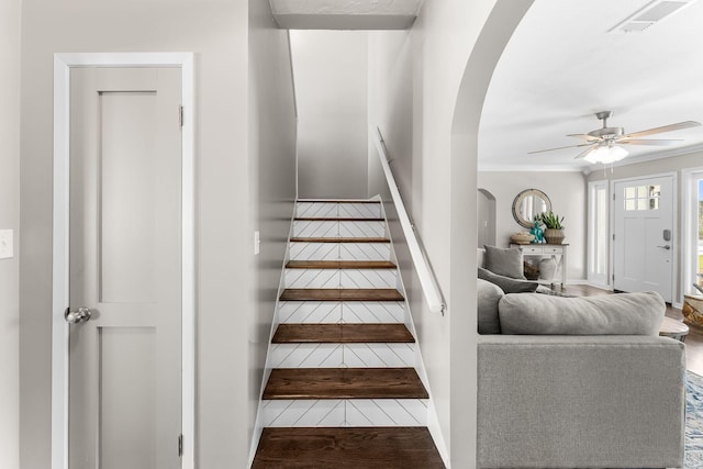 stairs with a ceiling fan, wood finished floors, arched walkways, and visible vents