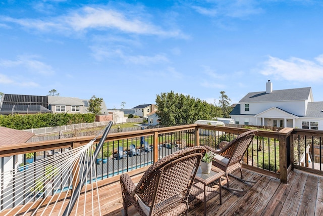 wooden deck with a residential view, a fenced in pool, and fence