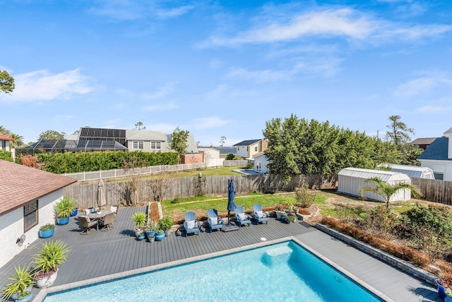 view of pool with an outbuilding, a deck, a fenced in pool, and a fenced backyard