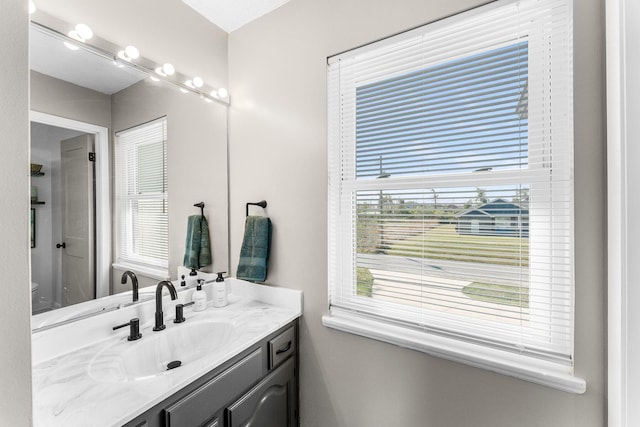 bathroom with toilet, vanity, and a shower