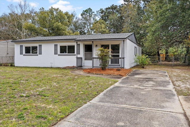 ranch-style home with stucco siding, covered porch, a front yard, and fence