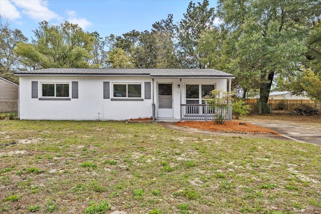 single story home with stucco siding, a porch, a front lawn, and fence