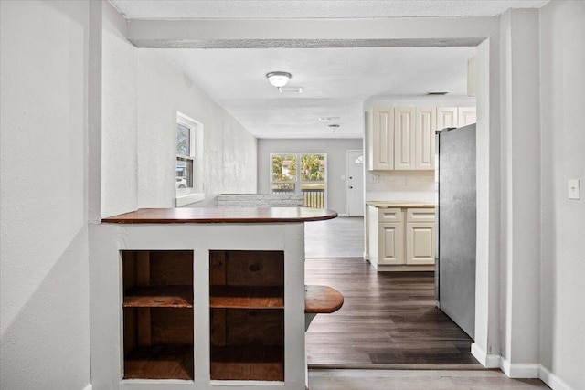 kitchen with dark wood finished floors, light countertops, baseboards, and freestanding refrigerator