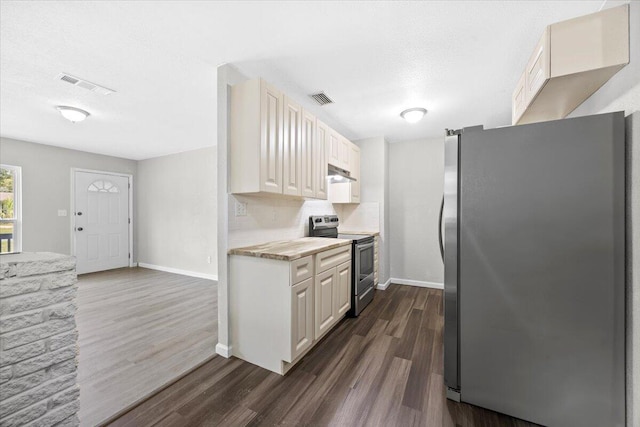 kitchen with under cabinet range hood, visible vents, appliances with stainless steel finishes, and light countertops