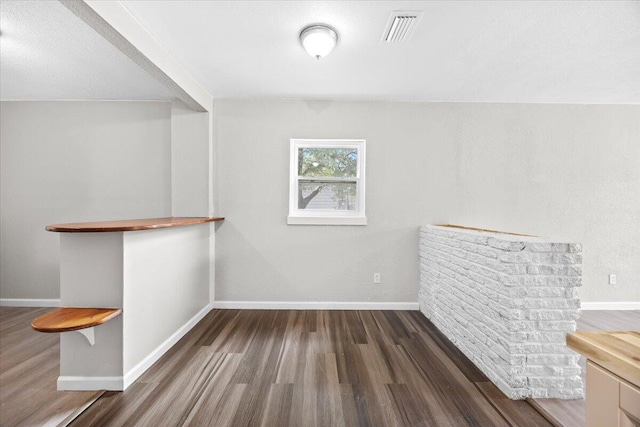 interior space with visible vents, baseboards, and wood finished floors