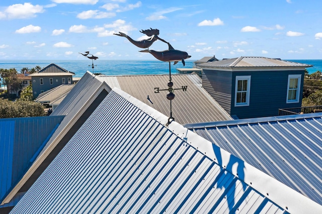 view of side of home with metal roof and a water view