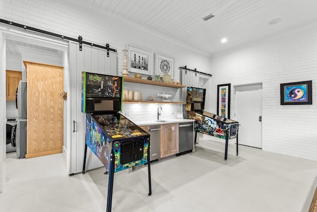 interior space with a sink, a barn door, and brick wall