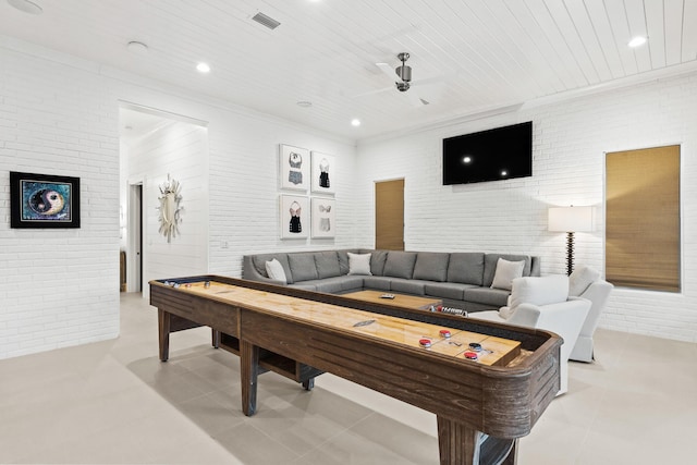 game room with light tile patterned floors, visible vents, and brick wall