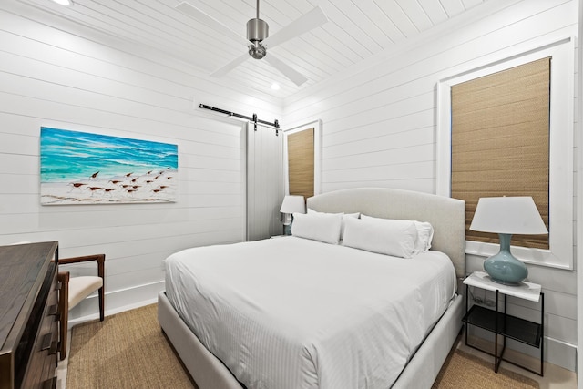 bedroom with baseboards, a ceiling fan, and a barn door