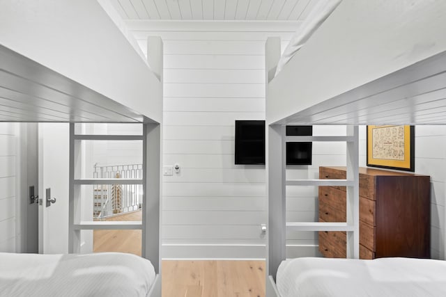 bedroom featuring wooden walls and wood finished floors