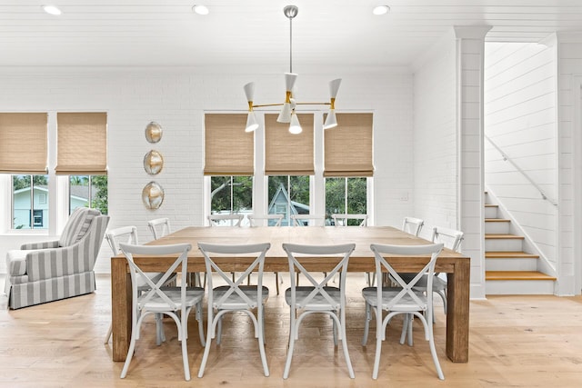 dining area featuring stairway, recessed lighting, light wood-type flooring, and brick wall