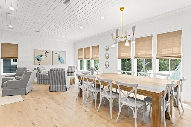 dining room featuring light wood-type flooring, wood ceiling, brick wall, and visible vents