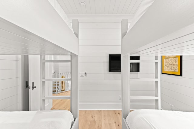 bedroom with wood ceiling, wood finished floors, and wood walls