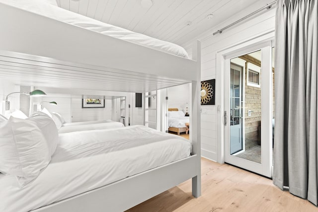 bedroom with access to outside, light wood-style flooring, and wood ceiling