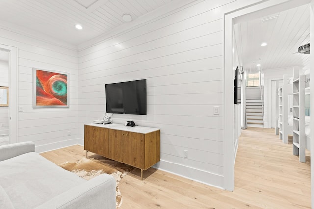 living area featuring stairway, baseboards, and light wood finished floors