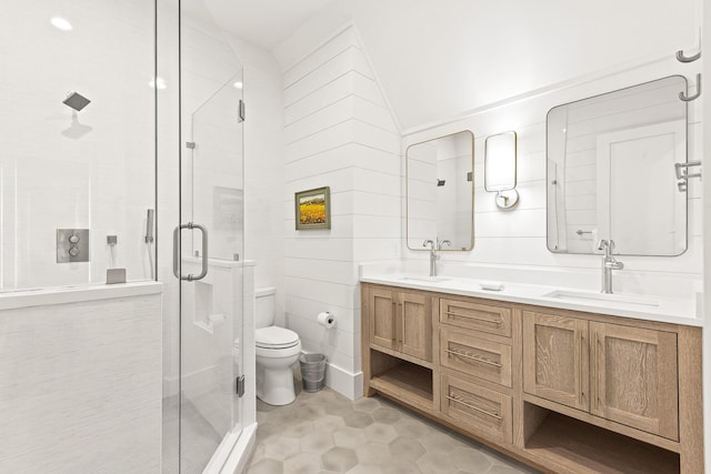 bathroom featuring toilet, a stall shower, and a sink