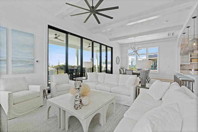 living area featuring beamed ceiling, ceiling fan with notable chandelier, visible vents, and a healthy amount of sunlight