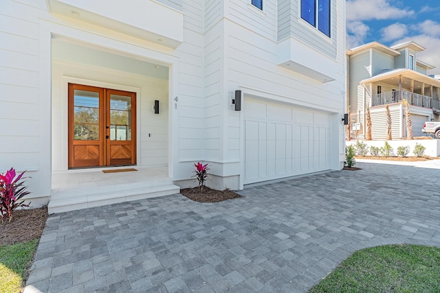 entrance to property with decorative driveway and a garage