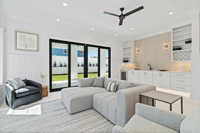 living area featuring beverage cooler, recessed lighting, indoor wet bar, and ornamental molding