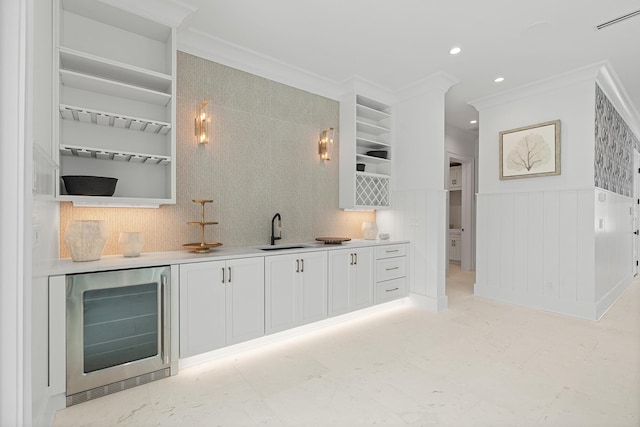 bar featuring a wainscoted wall, beverage cooler, a sink, recessed lighting, and crown molding