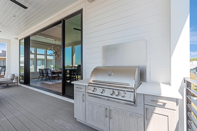 wooden deck with outdoor dining space, exterior kitchen, and area for grilling