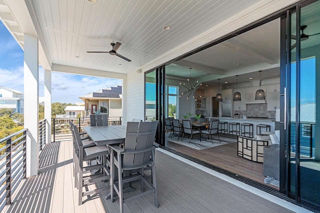 deck featuring outdoor dry bar, outdoor dining space, and a ceiling fan