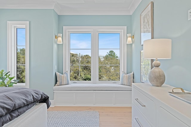 bedroom featuring light wood-style flooring, multiple windows, and ornamental molding