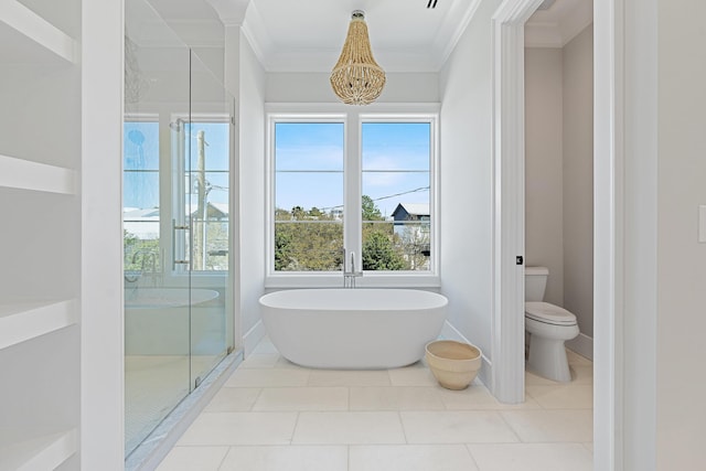 full bathroom featuring tile patterned floors, a freestanding tub, toilet, ornamental molding, and a shower stall