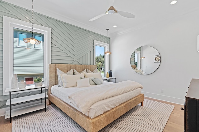 bedroom with recessed lighting, light wood-style flooring, crown molding, and baseboards