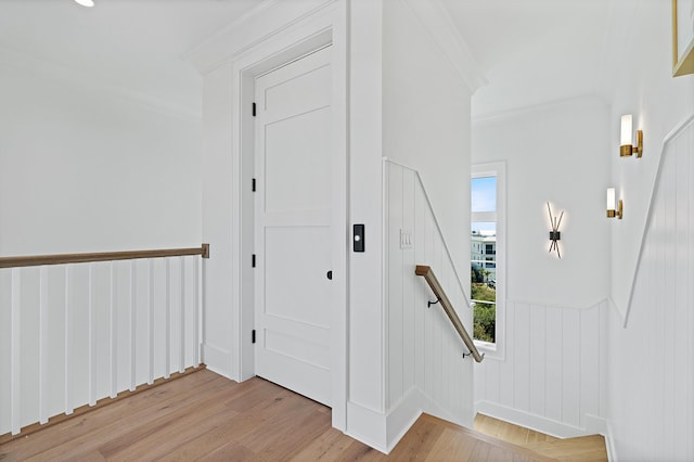 foyer with light wood-type flooring and crown molding