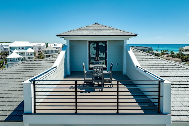 exterior space with a water view, a balcony, and a tile roof