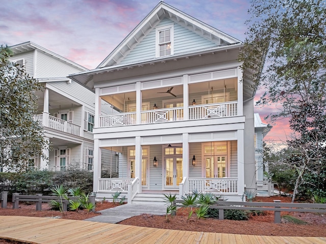 view of front of property featuring covered porch, french doors, and a balcony