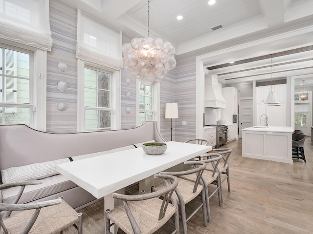 dining space with light wood finished floors, visible vents, beamed ceiling, and breakfast area