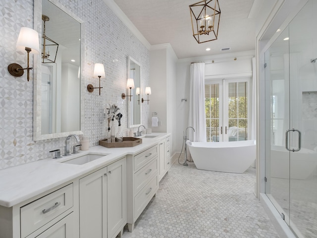 bathroom with double vanity, a soaking tub, a stall shower, and a sink