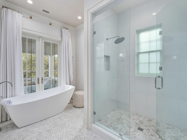 full bathroom featuring visible vents, a soaking tub, recessed lighting, a shower stall, and french doors