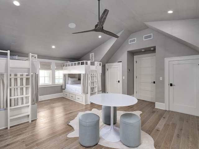 bedroom with vaulted ceiling, visible vents, and wood finished floors