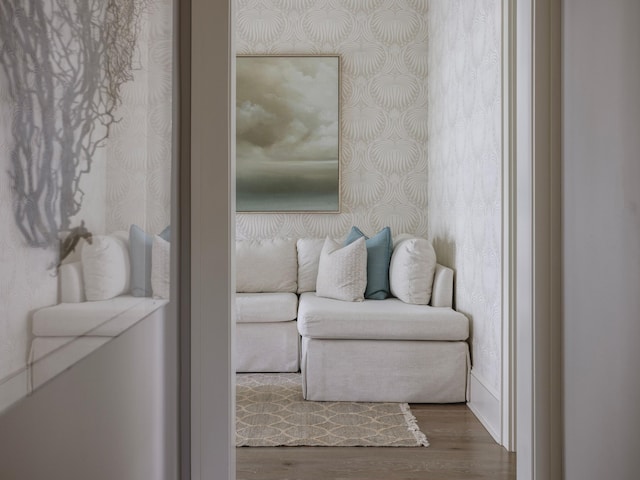 sitting room with wallpapered walls and wood finished floors