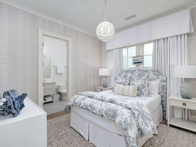 bedroom featuring wood finished floors, visible vents, wallpapered walls, ensuite bath, and ornamental molding