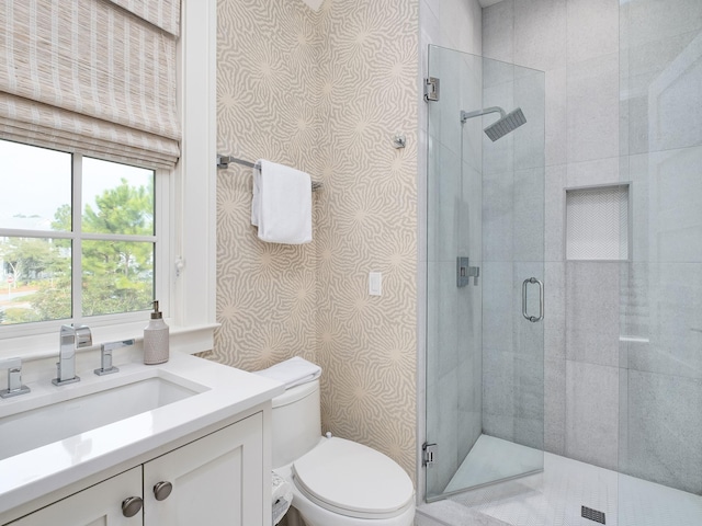 full bathroom featuring vanity, toilet, a shower stall, and wallpapered walls